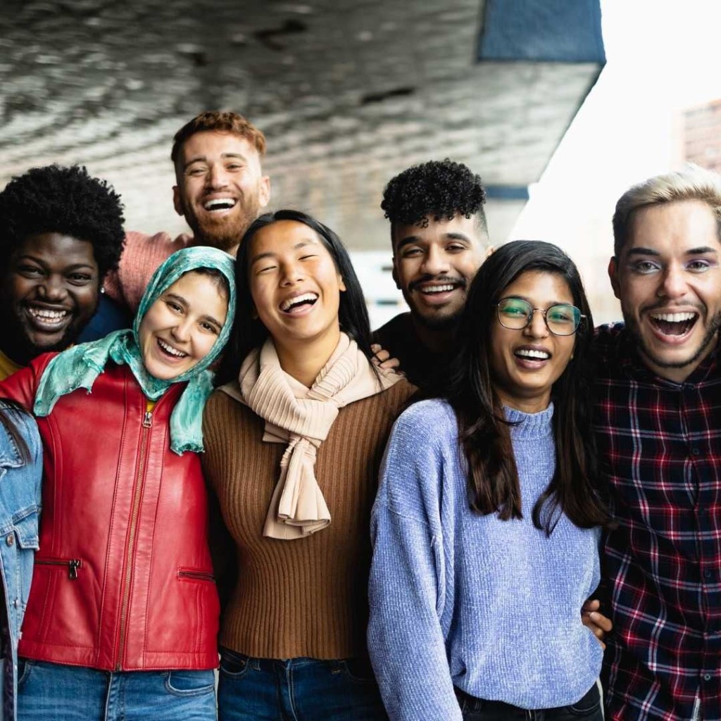 Diverse group of adults laughing together in an inclusive community setting